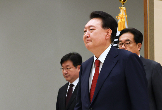 윤석열 대통령이 12일 서울 용산 대통령실 청사에서 조지호 경찰청장에게 임명장을 수여한 뒤 환담장으로 향하고 있다.<연합뉴스>